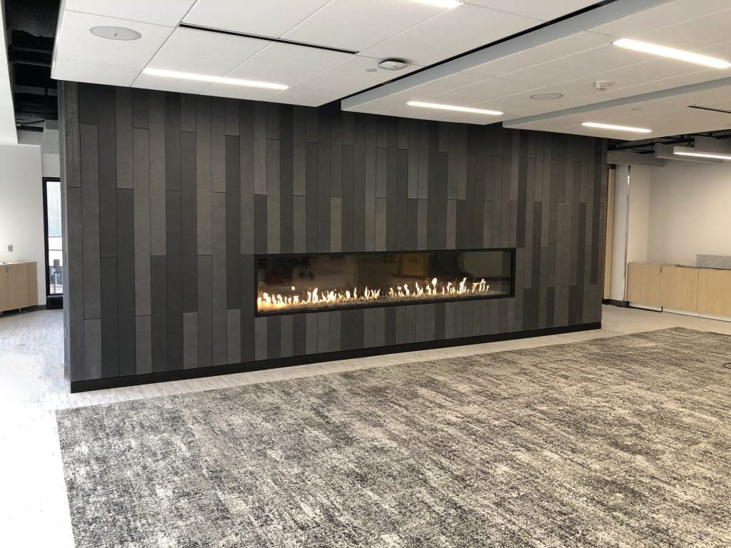 A gas fireplace with a fluted textured surround in a sophisticated living room.