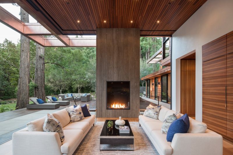 An outdoor gas fireplace on a cozy patio, surrounded by comfortable seating and ambient lighting.