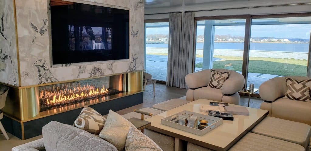 A modern gas fireplace with a two-tone surround featuring matte black and brushed steel accents.