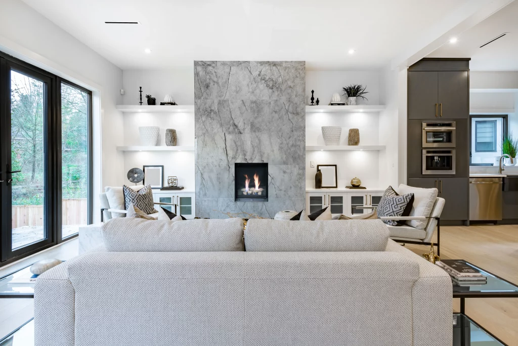 modern white and gray living room with tall vertical direct vent gas fireplace with stone media